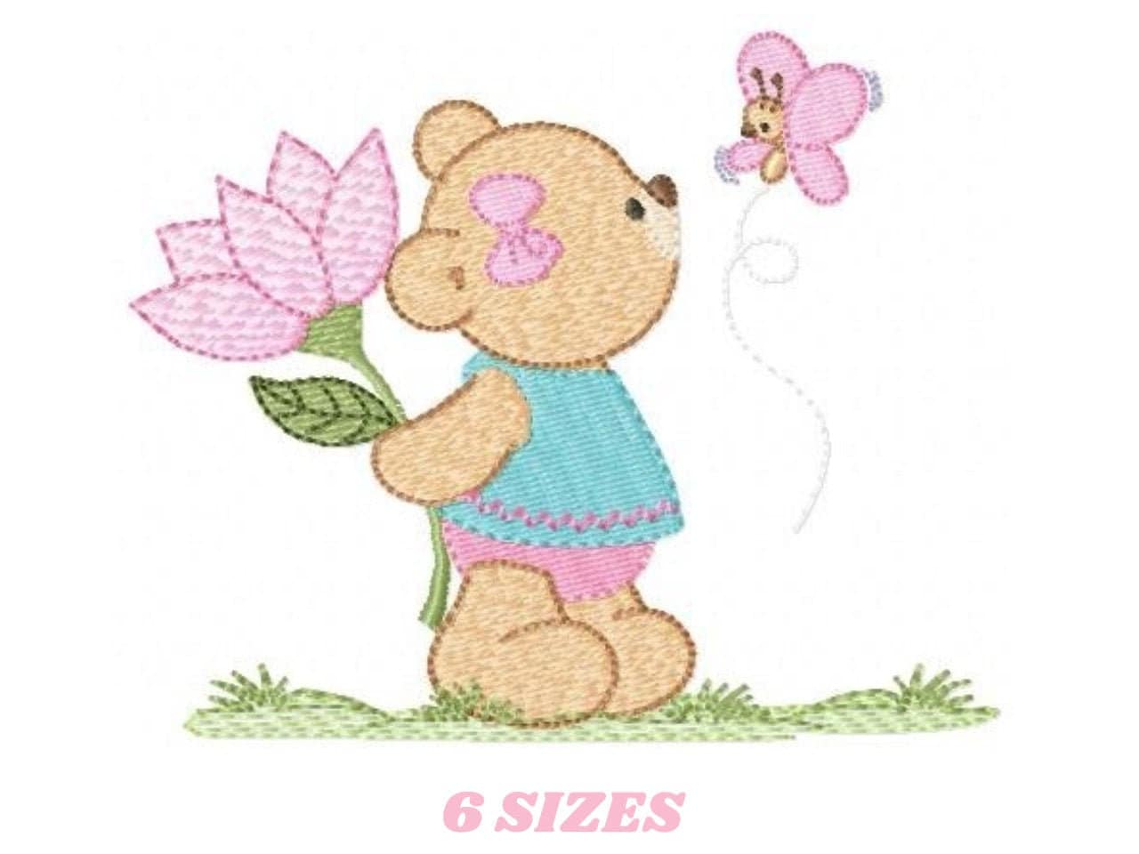 May include: Embroidered design of a brown teddy bear holding a pink flower and looking at a pink butterfly. The bear is wearing a blue dress with pink trim and pink shoes. The design is set against a green grassy background.