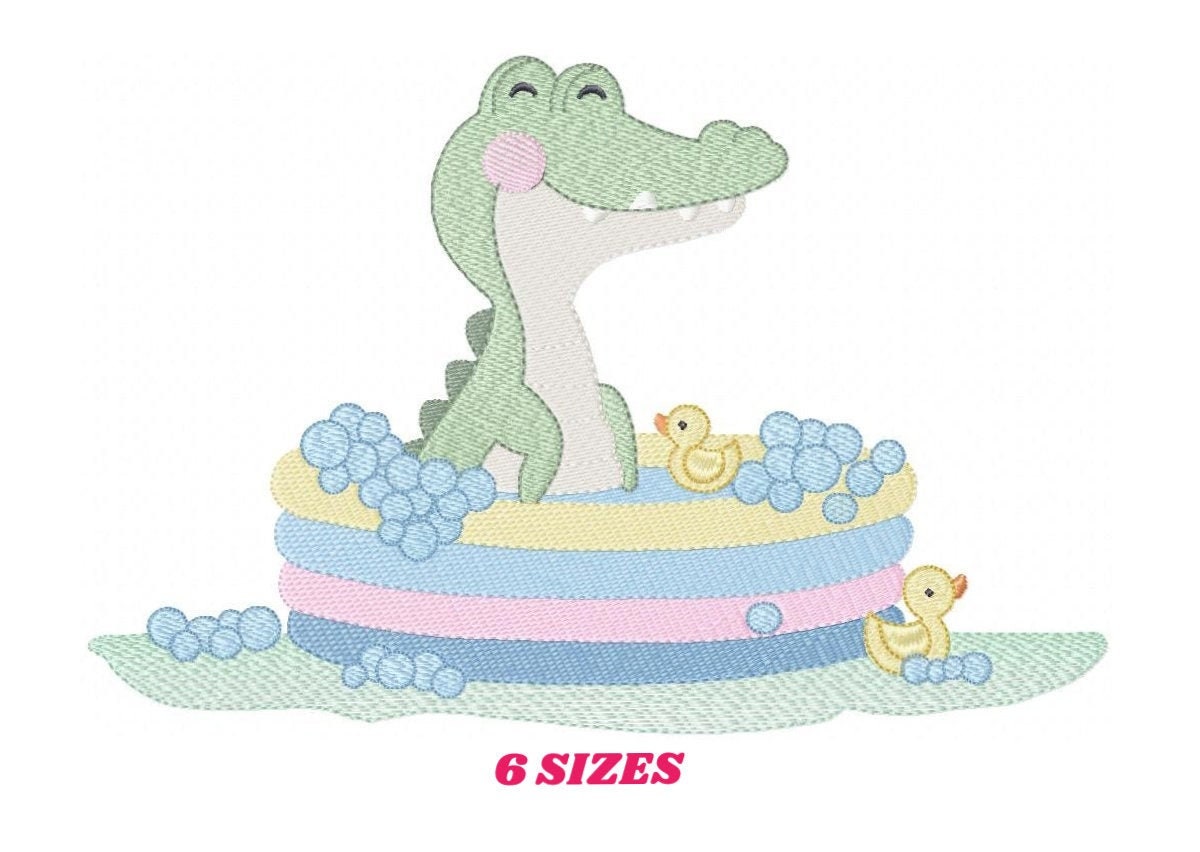 May include: A green alligator with a pink blush is sitting in a blue, pink, and yellow inflatable pool with two yellow rubber duckies. There are blue bubbles around the pool and on the green grass.