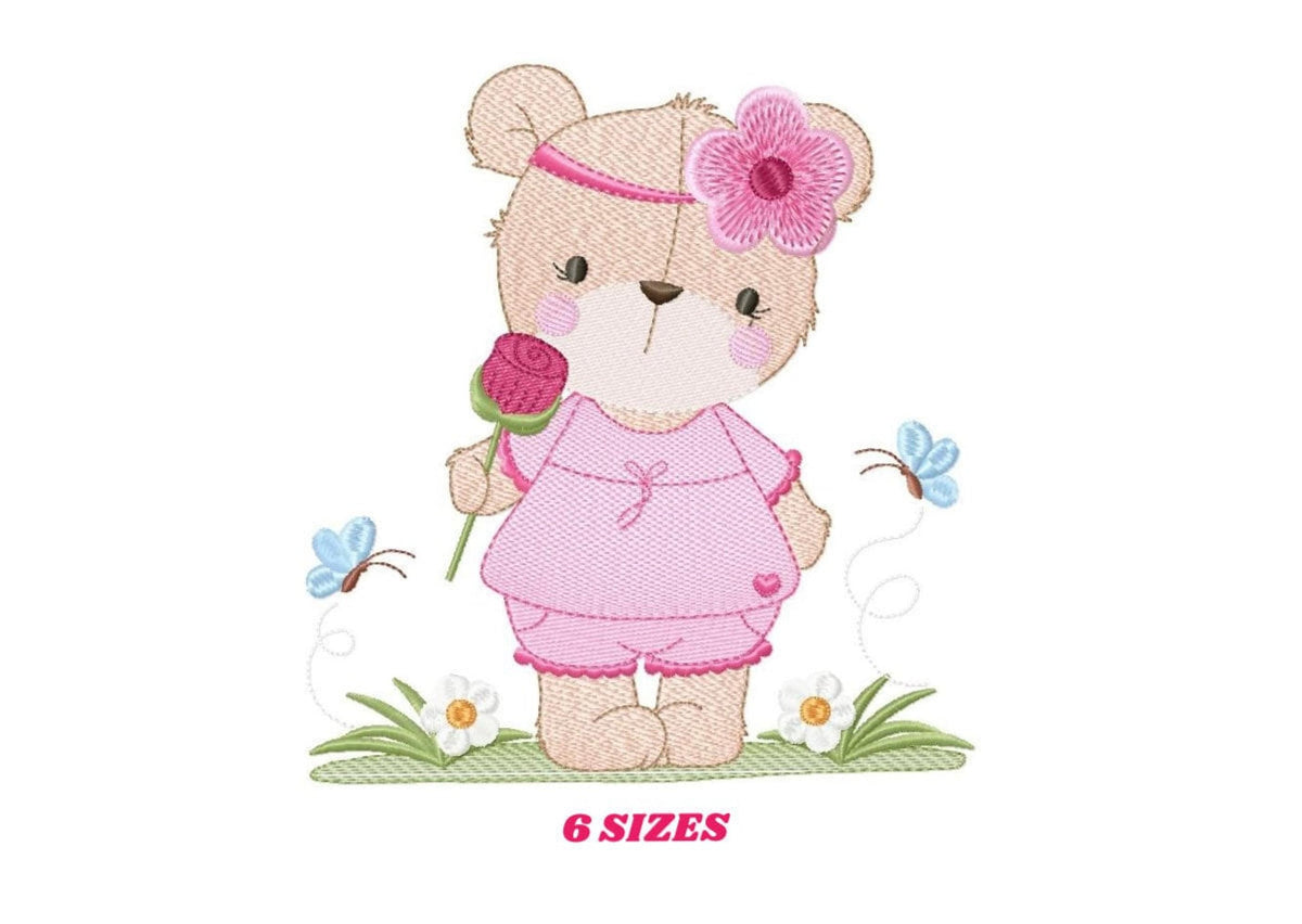Sweet standing teddy bear embroidery design, pink dress, large pink flower headband, grass and blue butterfly