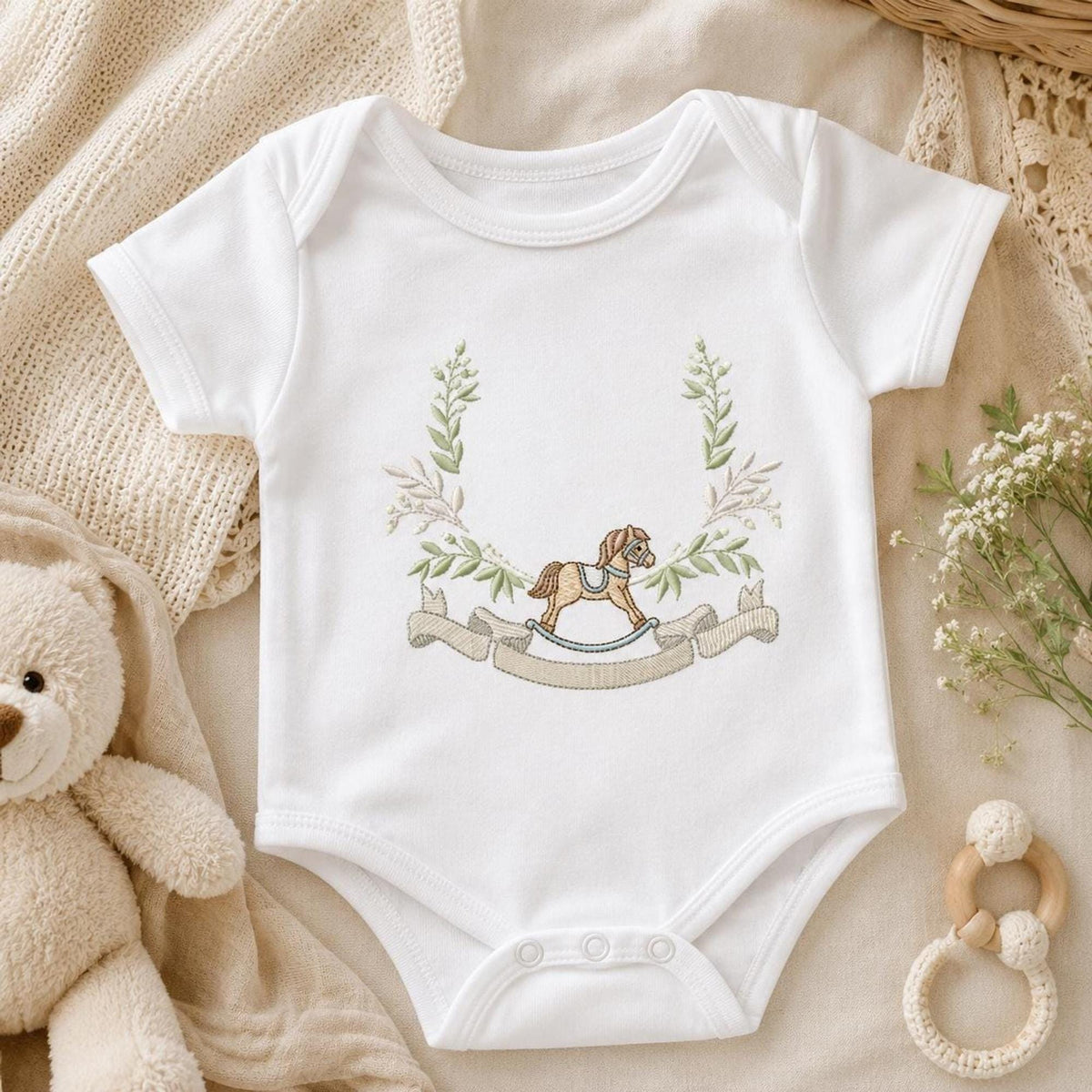 White baby bodysuit styled with cradle animals and floral frame, baby bodysuit embroidery pattern in cottagecore pastels