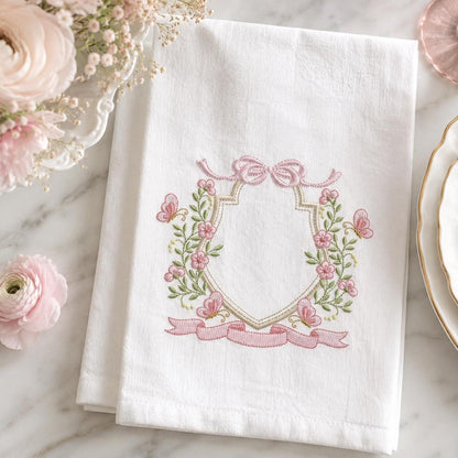 Folded white towel with delicate pink floral wreath embroidery, nursery embroidery designs and monogram frame option